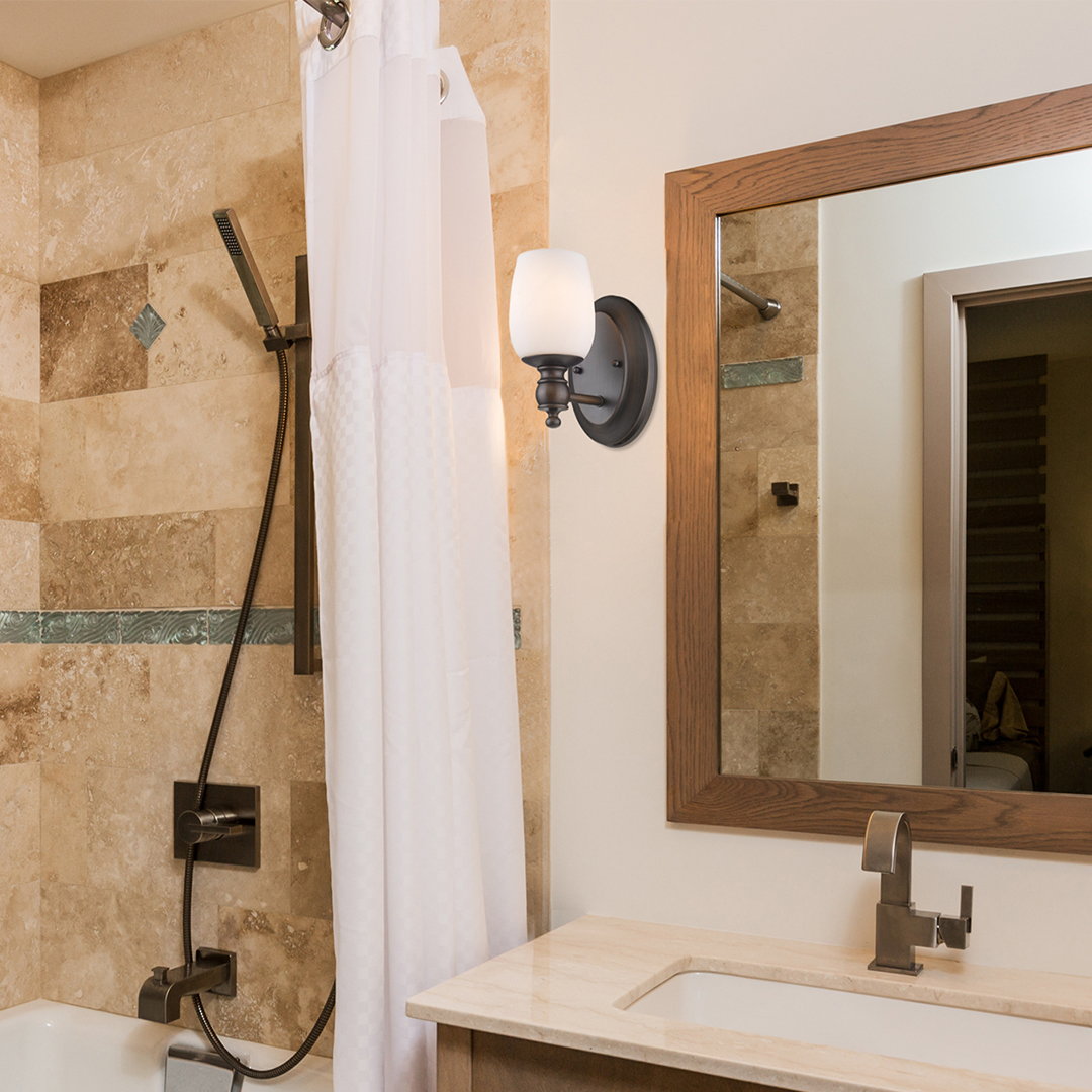 beautiful bathroom with sconces around mirror